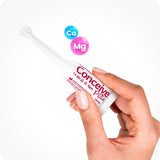 Image of Conceive Plus try me size fertility lubricant applicators 4g in hand of a female on a white background. White applicator has pink branding and text highlighting manufacturers info, company website url, quantity of the lube, Made in France, and storage instructions. Two 3d bubbles with chemical formulas of Calcium and Magnesium ions are floating in the frame.