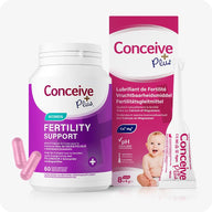 Conceive Plus Women's Fertility Support + Applicators (FR) product image displaying a white and purple bottle of women fertility support capsules alongside an 8x4g pre-filled fertility lubricant applicators box, with French, Dutch, and German language text on packaging and a baby graphic; pink capsules and one applicator are also visible in foreground on a white background.